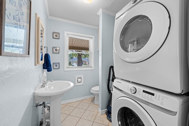 197 Country Club Rd, Shalimar, FL 32579 - bathroom featuring stacked washer / drying machine, crown molding, a textured ceiling, tile patterned floors, and toilet