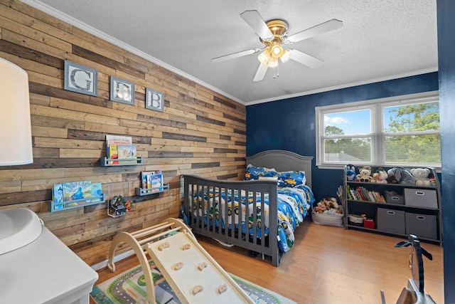 197 Country Club Rd, Shalimar, FL 32579 - bedroom featuring a textured ceiling, wood finished floors, ornamental molding, wooden walls, and a ceiling fan