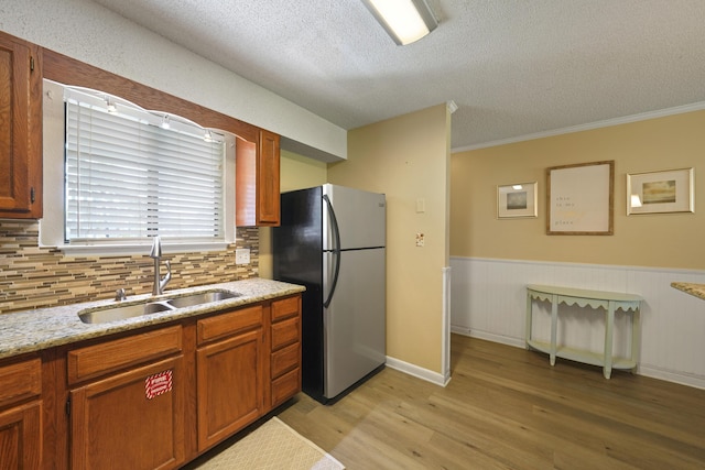 3755 Scenic Highway 98 Unit 1601, Destin, FL 32541 - kitchen featuring freestanding refrigerator, a sink, a textured ceiling, light wood-type flooring, and backsplash