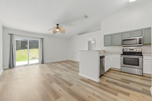 kitchen featuring stainless steel appliances, a ceiling fan, a peninsula, light wood-style floors, and light countertops