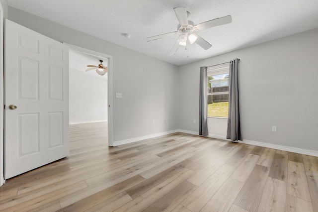 unfurnished room with a ceiling fan, light wood-style floors, and baseboards