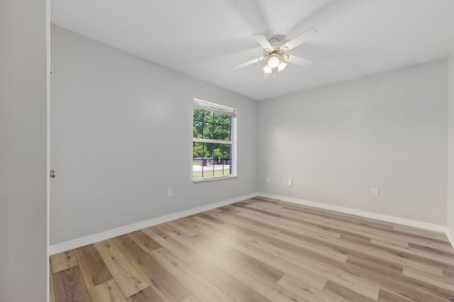 empty room featuring ceiling fan, light wood-style floors, and baseboards