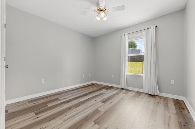 empty room featuring light wood-style flooring, baseboards, and ceiling fan