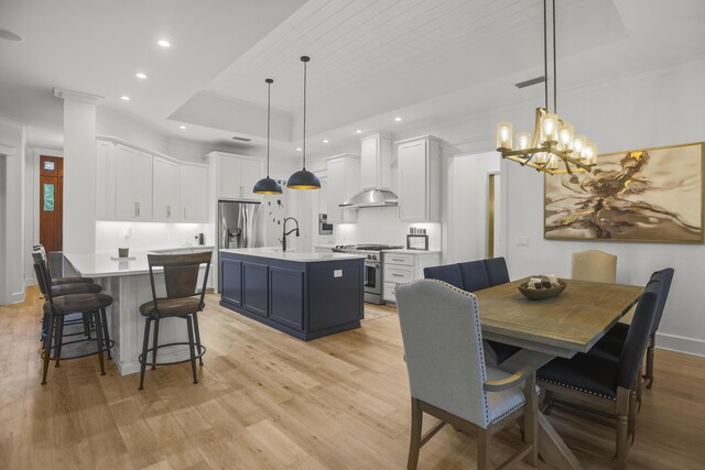 1807 Lost Cove Ct, Panama City Beach, FL 32413 - dining area with a tray ceiling, light wood-style flooring, recessed lighting, a chandelier, and crown molding