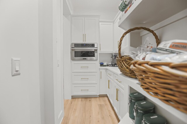 1807 Lost Cove Ct, Panama City Beach, FL 32413 - kitchen with light wood-style flooring, stainless steel oven, white cabinetry, and light countertops