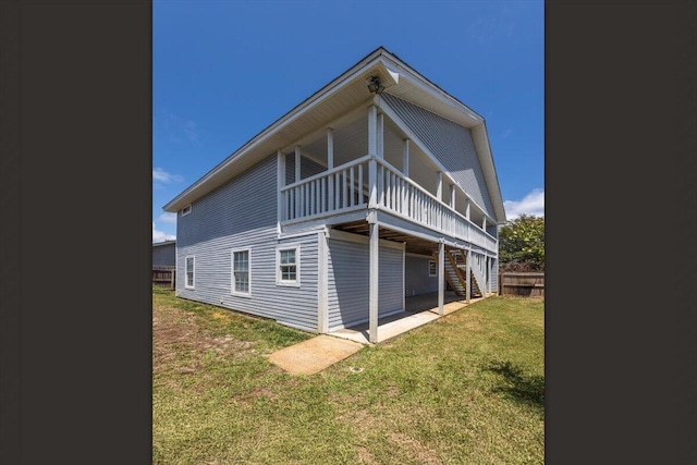 rear view of house with stairway, a lawn, and a deck