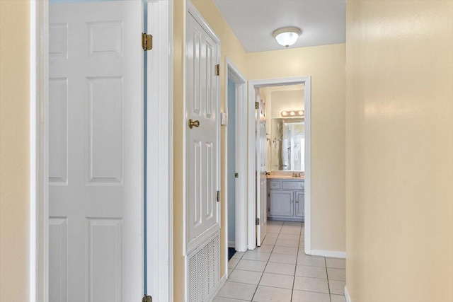 hall with light tile patterned flooring and baseboards