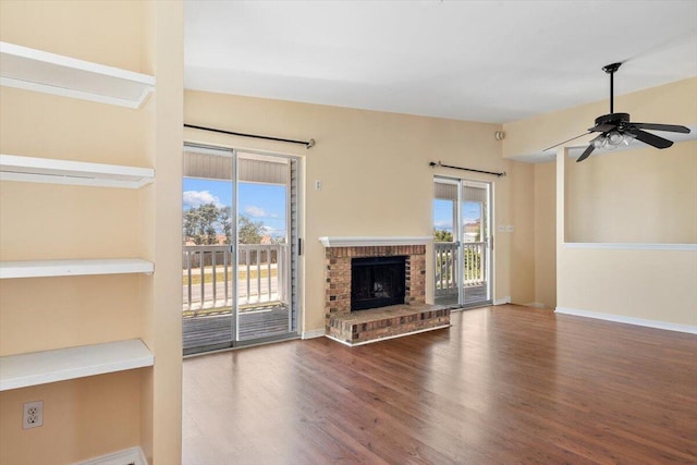 unfurnished living room with wood finished floors, ceiling fan, a fireplace, and baseboards