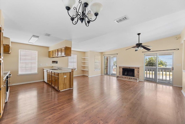 kitchen featuring brown cabinets, a sink, ceiling fan, dark wood-style flooring, and light countertops