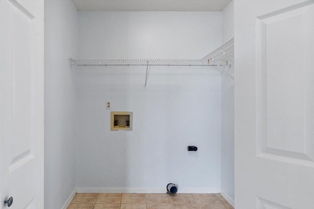 clothes washing area featuring hookup for an electric dryer, washer hookup, baseboards, and light tile patterned flooring