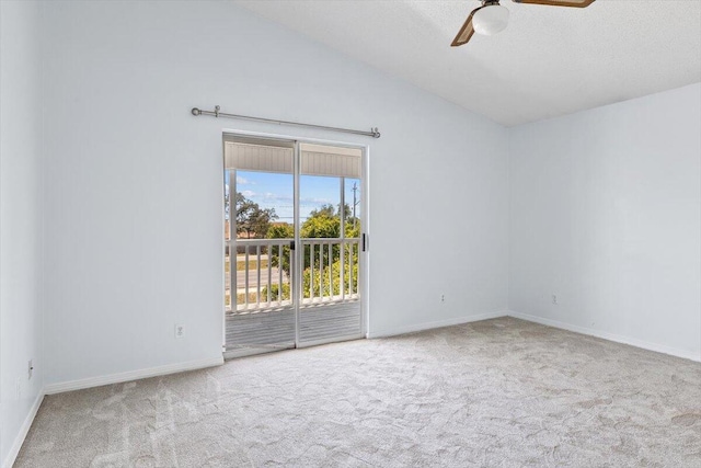 carpeted spare room featuring ceiling fan, baseboards, vaulted ceiling, and a textured ceiling