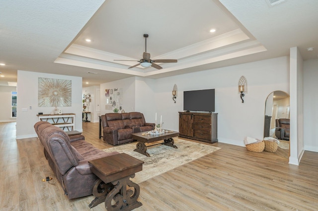 602 Champ Trl, Crestview, FL 32539 - living room featuring a tray ceiling, light wood-style floors, arched walkways, a ceiling fan, and recessed lighting