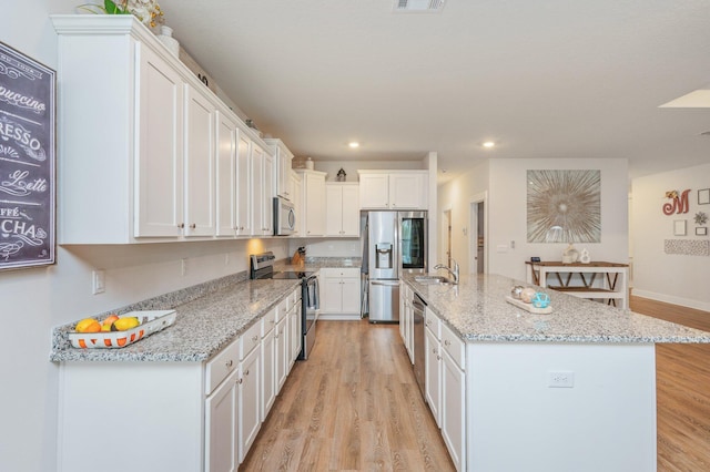 602 Champ Trl, Crestview, FL 32539 - kitchen featuring appliances with stainless steel finishes, a sink, white cabinets, light wood finished floors, and recessed lighting