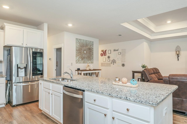 602 Champ Trl, Crestview, FL 32539 - kitchen with stainless steel appliances, a sink, light wood-style floors, a center island with sink, and light stone countertops