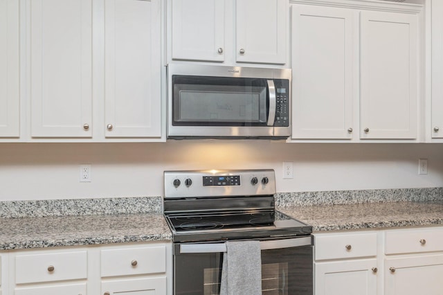 602 Champ Trl, Crestview, FL 32539 - kitchen with appliances with stainless steel finishes, white cabinets, and light stone countertops