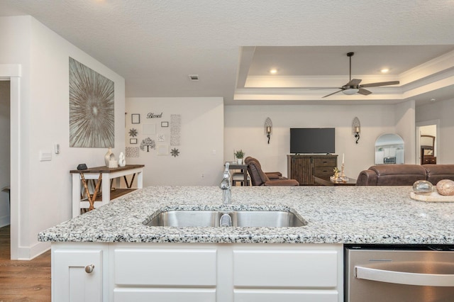 602 Champ Trl, Crestview, FL 32539 - kitchen featuring a sink, dishwasher, a tray ceiling, wood finished floors, and open floor plan