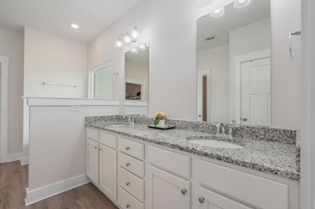 602 Champ Trl, Crestview, FL 32539 - bathroom featuring wood finished floors, double vanity, and baseboards