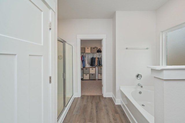 602 Champ Trl, Crestview, FL 32539 - bathroom with a shower stall, a spacious closet, wood finished floors, and a bath
