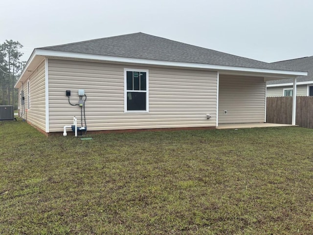 back of property with a patio, roof with shingles, and cooling unit