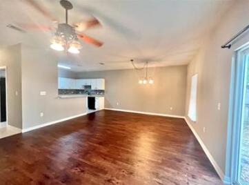 1413 Beaver Run Rd Unit 7, Niceville, FL 32578 - unfurnished living room with wood finished floors, a ceiling fan, and baseboards