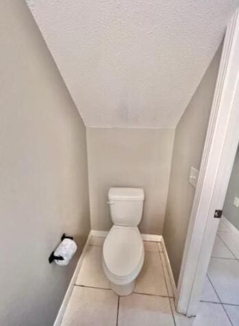 1413 Beaver Run Rd Unit 7, Niceville, FL 32578 - bathroom featuring a textured ceiling, tile patterned flooring, vaulted ceiling, toilet, and baseboards