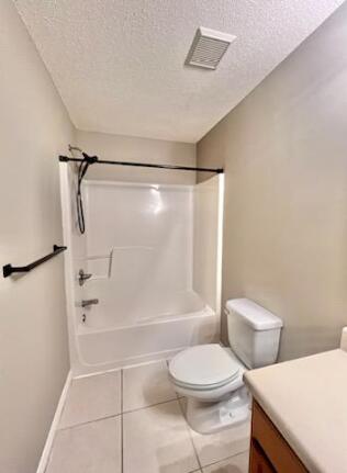 1413 Beaver Run Rd Unit 7, Niceville, FL 32578 - full bathroom featuring a textured ceiling, tile patterned flooring, vanity, baseboards, and toilet