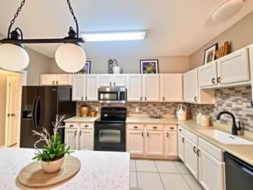 1413 Beaver Run Rd Unit 7, Niceville, FL 32578 - kitchen with black appliances, a sink, light countertops, and decorative backsplash