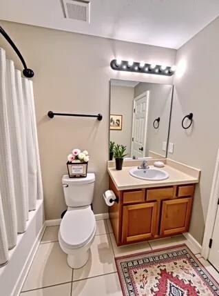 1413 Beaver Run Rd Unit 7, Niceville, FL 32578 - full bathroom with toilet, tile patterned flooring, vanity, shower / tub combo with curtain, and baseboards