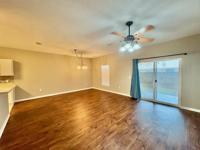 1413 Beaver Run Rd Unit 7, Niceville, FL 32578 - unfurnished living room with a chandelier, a ceiling fan, dark wood-style floors, and a textured ceiling
