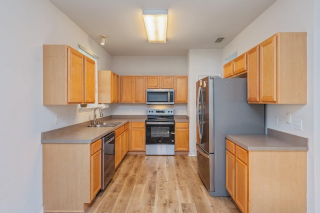 613 Prairie St, Crestview, FL 32536 - kitchen featuring appliances with stainless steel finishes, a sink, light wood-type flooring, and light brown cabinetry