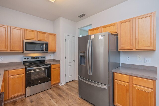 613 Prairie St, Crestview, FL 32536 - kitchen with stainless steel appliances, light wood-type flooring, and light brown cabinets