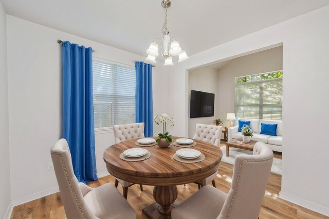 613 Prairie St, Crestview, FL 32536 - dining area with a chandelier, light wood-style flooring, and baseboards