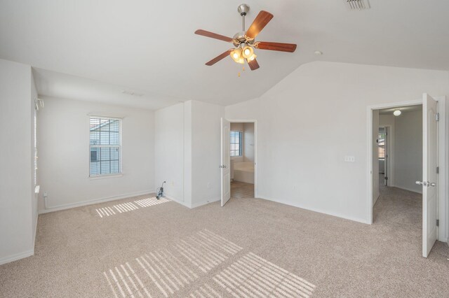613 Prairie St, Crestview, FL 32536 - unfurnished bedroom with light colored carpet, multiple windows, vaulted ceiling, and baseboards