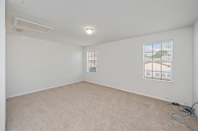 613 Prairie St, Crestview, FL 32536 - empty room featuring carpet, attic access, and plenty of natural light