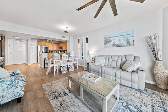 4207 Indian Bayou Trl Unit 2513, Destin, FL 32541 - living room with a ceiling fan, light wood-style floors, and baseboards