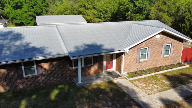3961 Painter Branch Rd, Crestview, FL 32539 - single story home featuring brick siding, metal roof, a forest view, and a front lawn