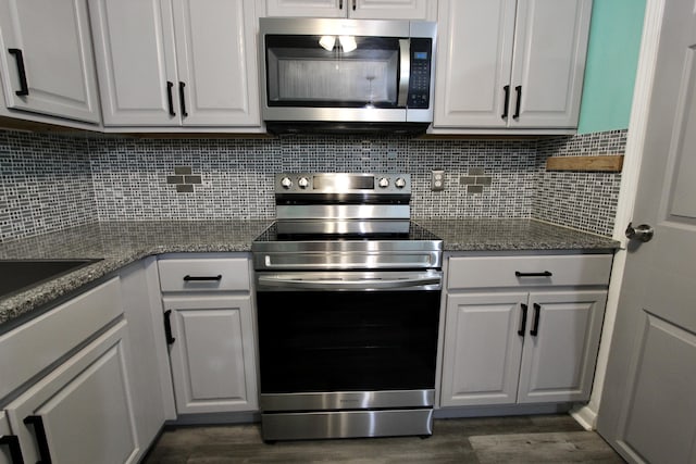 3961 Painter Branch Rd, Crestview, FL 32539 - kitchen with appliances with stainless steel finishes, dark wood-style flooring, white cabinets, and tasteful backsplash