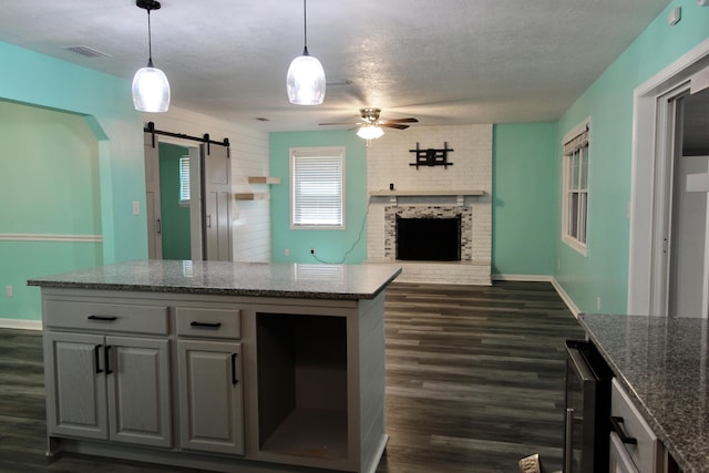 3961 Painter Branch Rd, Crestview, FL 32539 - kitchen featuring a barn door, dark wood-type flooring, a ceiling fan, open floor plan, and dark stone counters