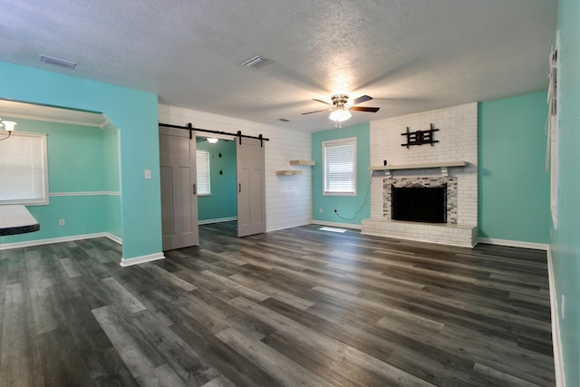 3961 Painter Branch Rd, Crestview, FL 32539 - unfurnished living room featuring a barn door, a textured ceiling, ceiling fan, dark wood-type flooring, and baseboards