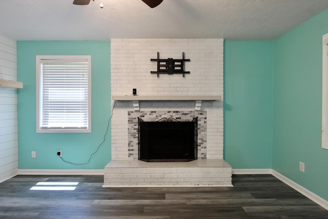 3961 Painter Branch Rd, Crestview, FL 32539 - unfurnished living room with a ceiling fan, a fireplace, wood finished floors, baseboards, and a textured ceiling
