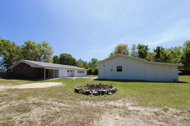 3961 Painter Branch Rd, Crestview, FL 32539 - view of grassy yard with an outdoor fire pit and a carport