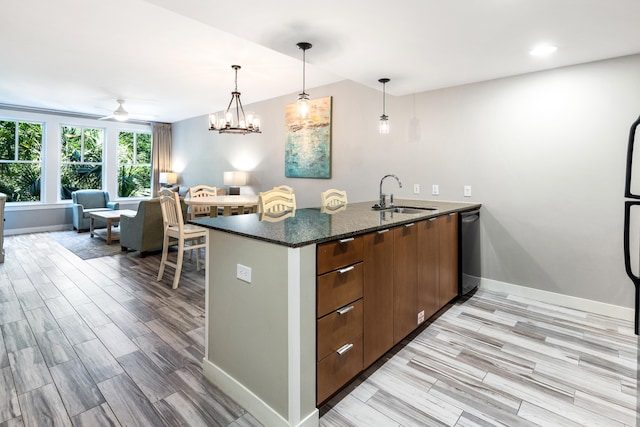 kitchen with a sink, dishwashing machine, baseboards, pendant lighting, and recessed lighting