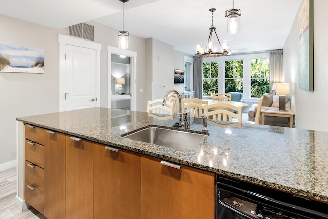 kitchen with a sink, dishwashing machine, brown cabinets, a chandelier, and stone counters