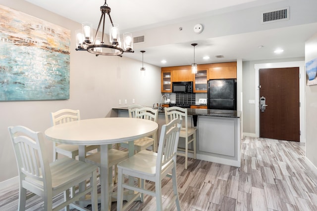 dining area with recessed lighting, a chandelier, light wood-style flooring, and baseboards