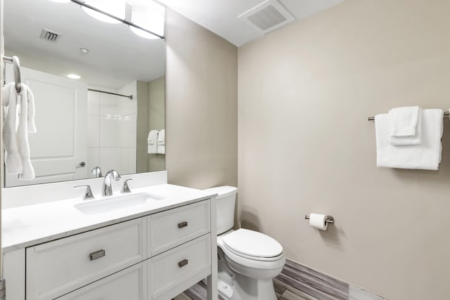 full bath with toilet, a shower, vanity, and wood finished floors