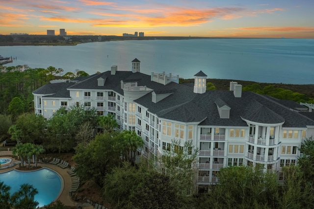 drone / aerial view of a nearby body of water and a pool