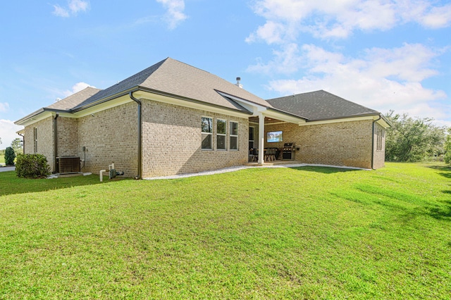 410 Coastal Breeze Dr, Freeport, FL 32439 - rear view of property with central AC, a patio area, a lawn, brick siding, and roof with shingles