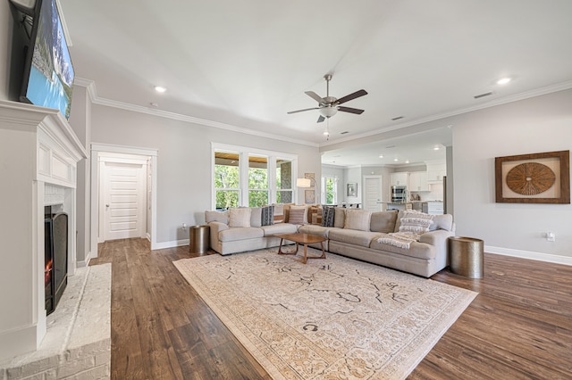 410 Coastal Breeze Dr, Freeport, FL 32439 - living area featuring ceiling fan, dark wood-style flooring, baseboards, a fireplace, and crown molding