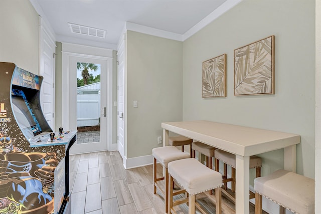 dining room featuring ornamental molding, baseboards, and wood finish floors