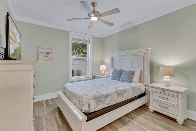 bedroom featuring light wood finished floors, baseboards, ceiling fan, and ornamental molding